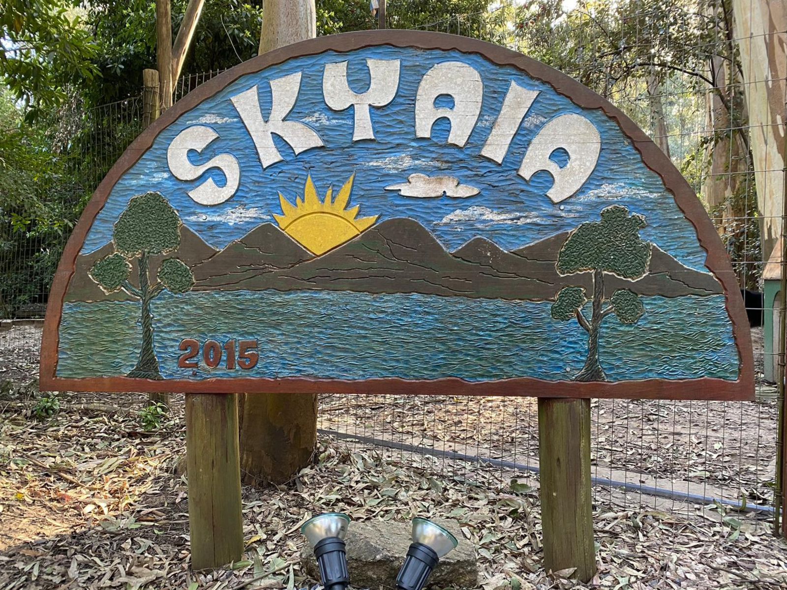 Skyaia entrance sign with sunrise design and mountains, showing the sanctuary name established in 2015